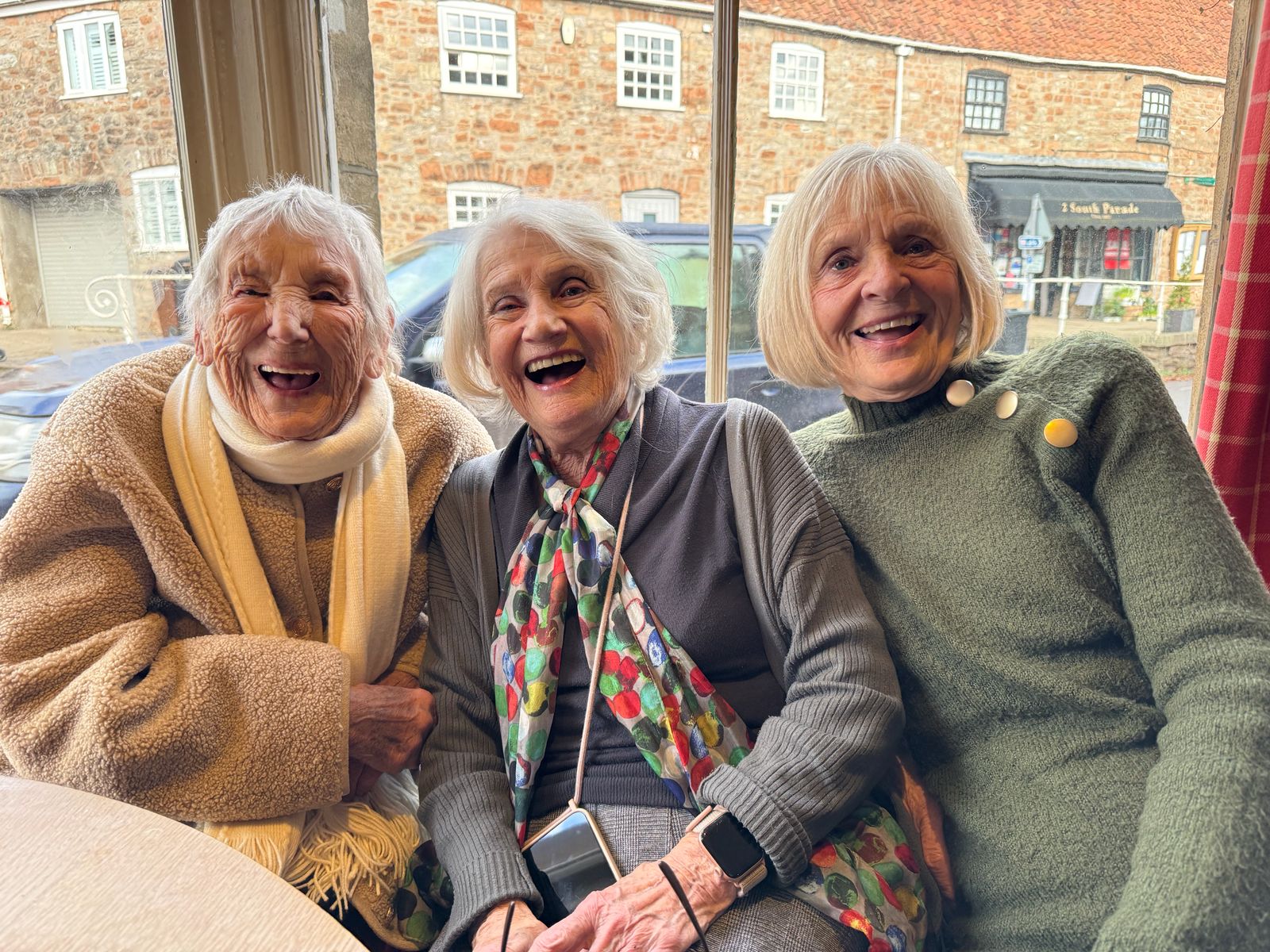 Three members laughing together at the pub