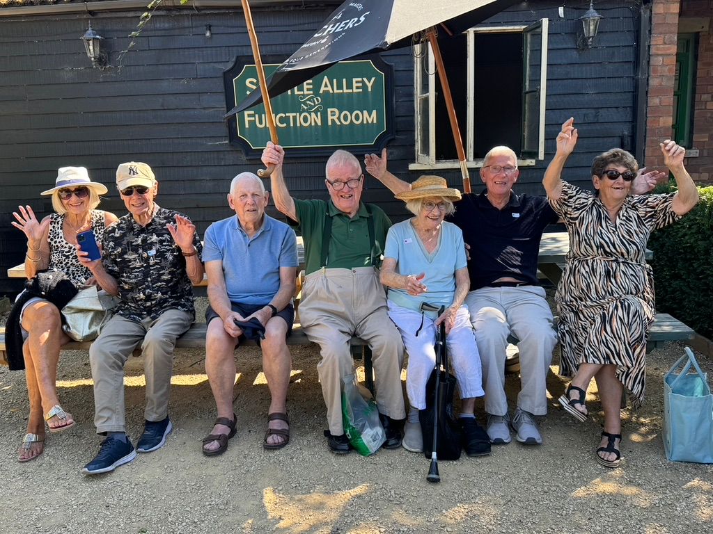 Chew Chatters waving on a bench outside the Skittle Alley
